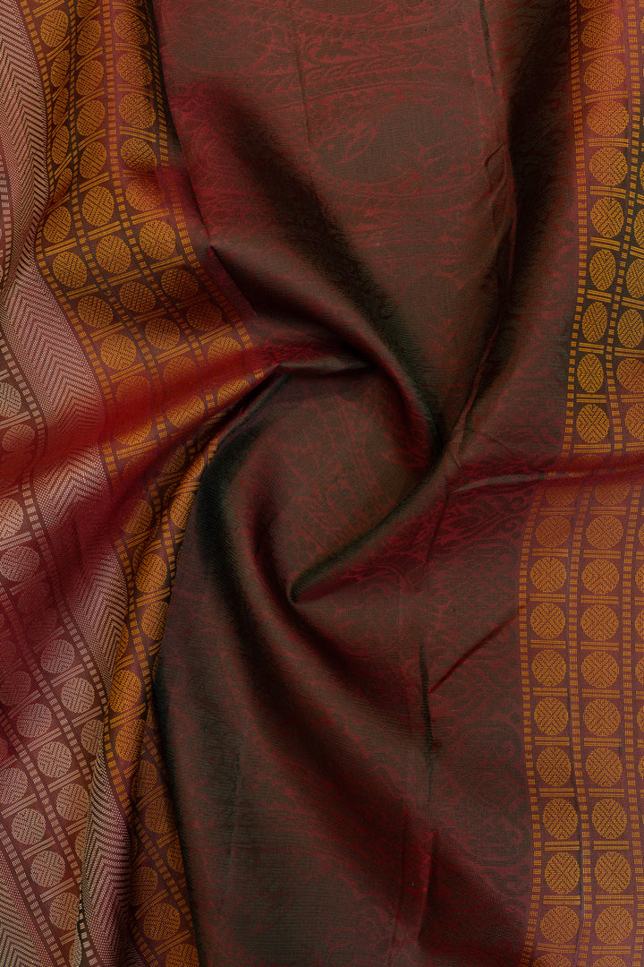Close-up of a maroon fabric with intricate patterns and borders