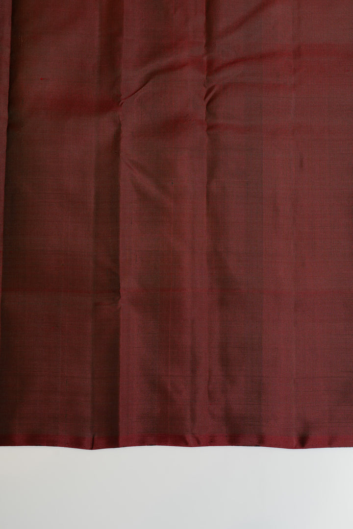 Close-up of dark red fabric with a textured pattern on a white background