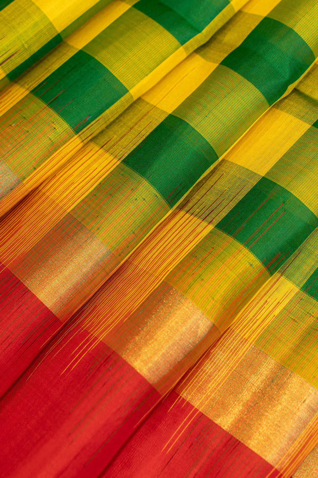 Close-up of a colorful fabric with green, yellow, and red checkered pattern.