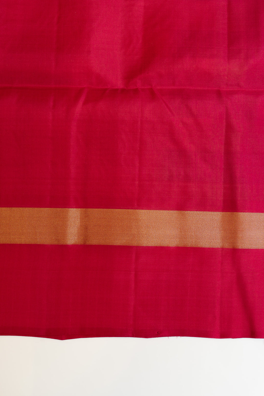 Close-up of a pink fabric with a brown border on a white background