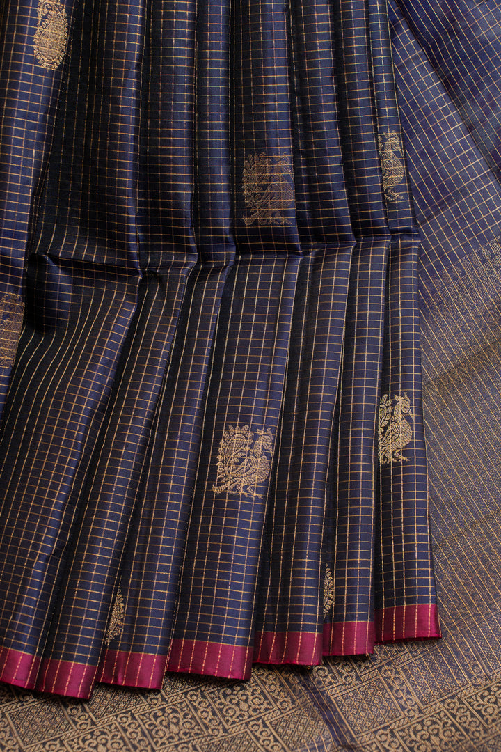 Blue and black checkered fabric with gold patterns and red borders on a textured surface.