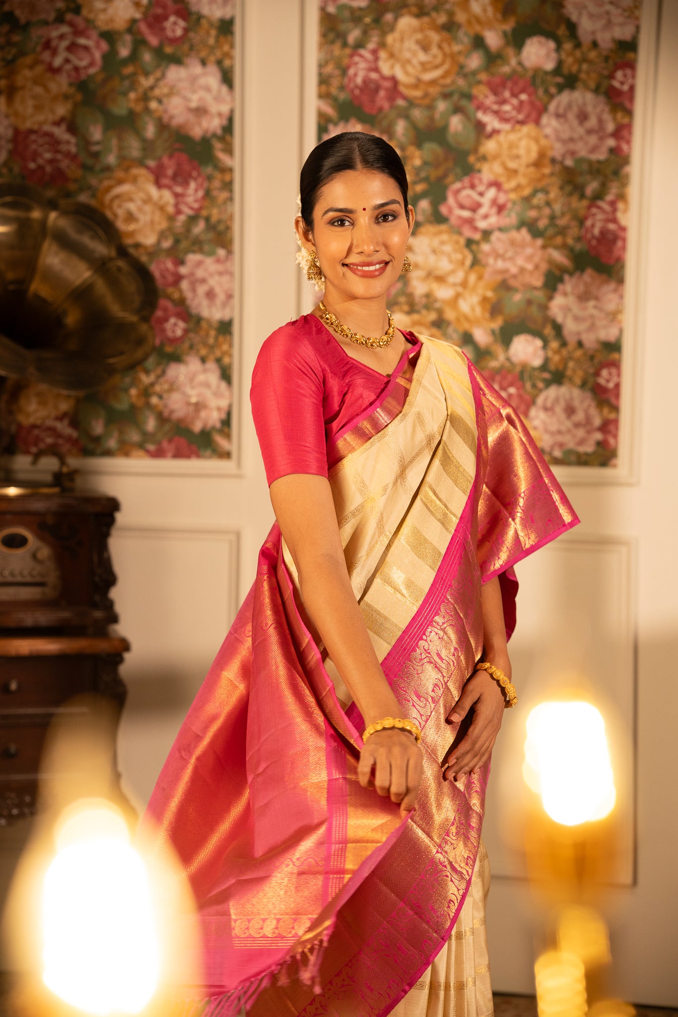 A woman gracefully wearing a Clio Silks Kanchipuram silk saree from the Varam Saree Collection, showcasing intricate handwoven patterns and vibrant colors.