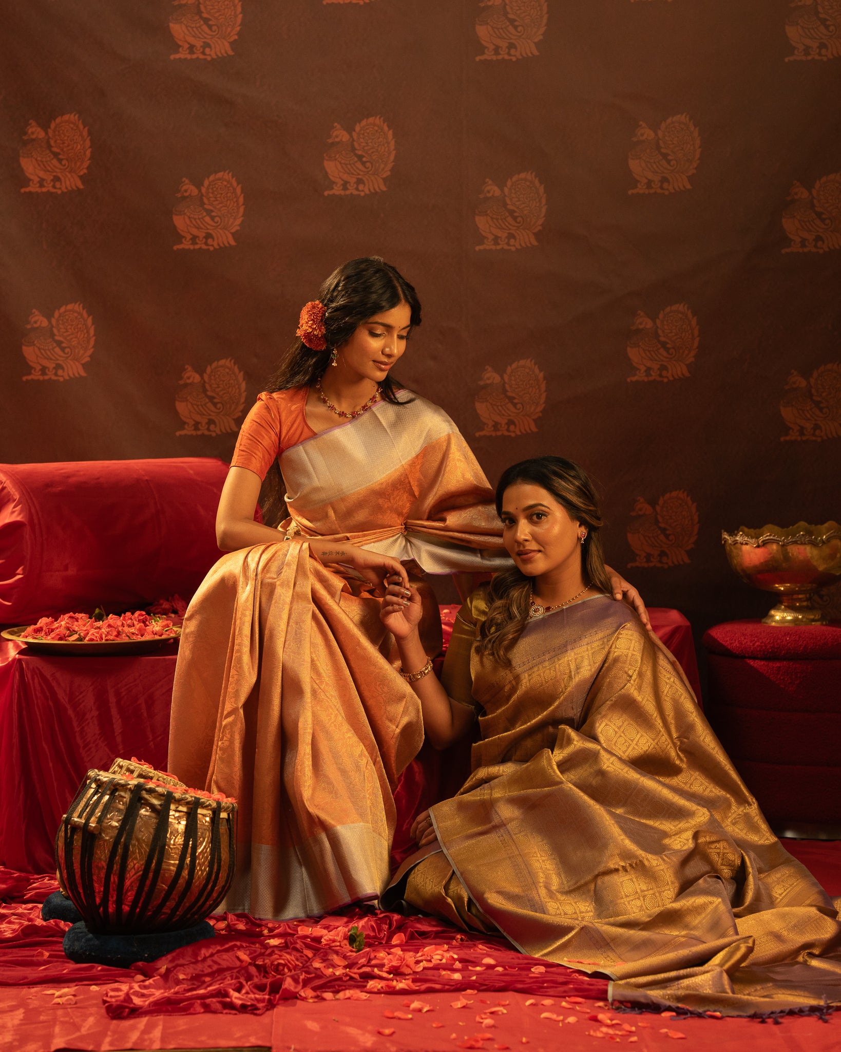 Two women silting in traditional Kanchipuram silk from clio silks.