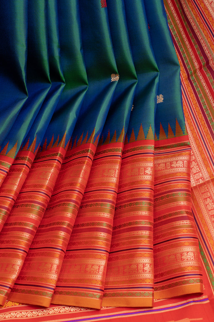 Full-length view of a Peacock Blue and Red pure Kanchipuram silk saree showcasing its intricate weave.