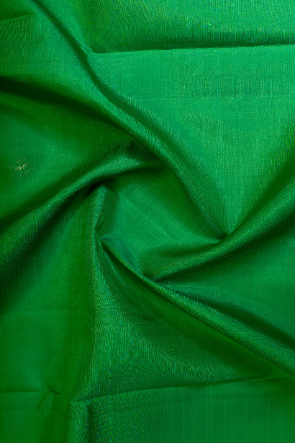 Closeup  body view of a parrot green and bottle green Kanjivaram silk saree with traditional chakram motifs, showcasing its vibrant colors