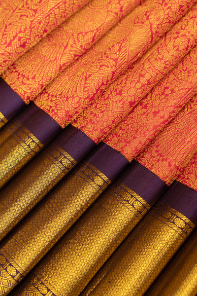 Close-up of the pleats of a crimson red Kanjivaram silk saree with detailed Iruthalaipakshi brocade motifs