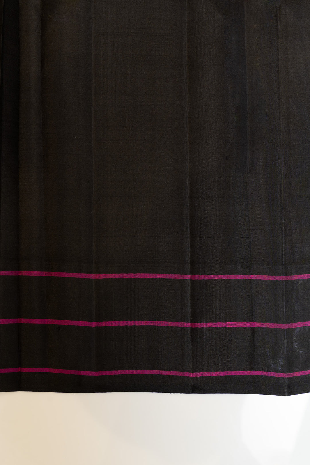 Black fabric with pink stripes on a white background