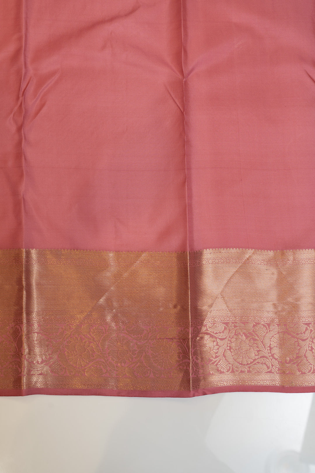 Pink saree with a brown border on a white background