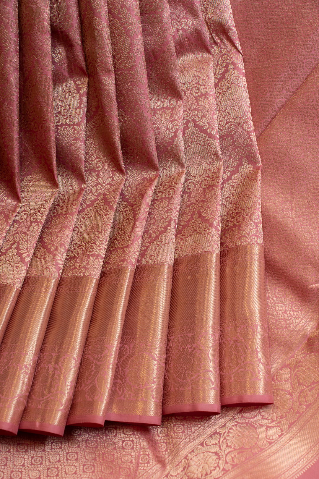 Pink saree with intricate patterns and a border