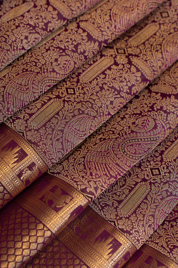 Close-up of patterned fabric with intricate designs in gold and purple.