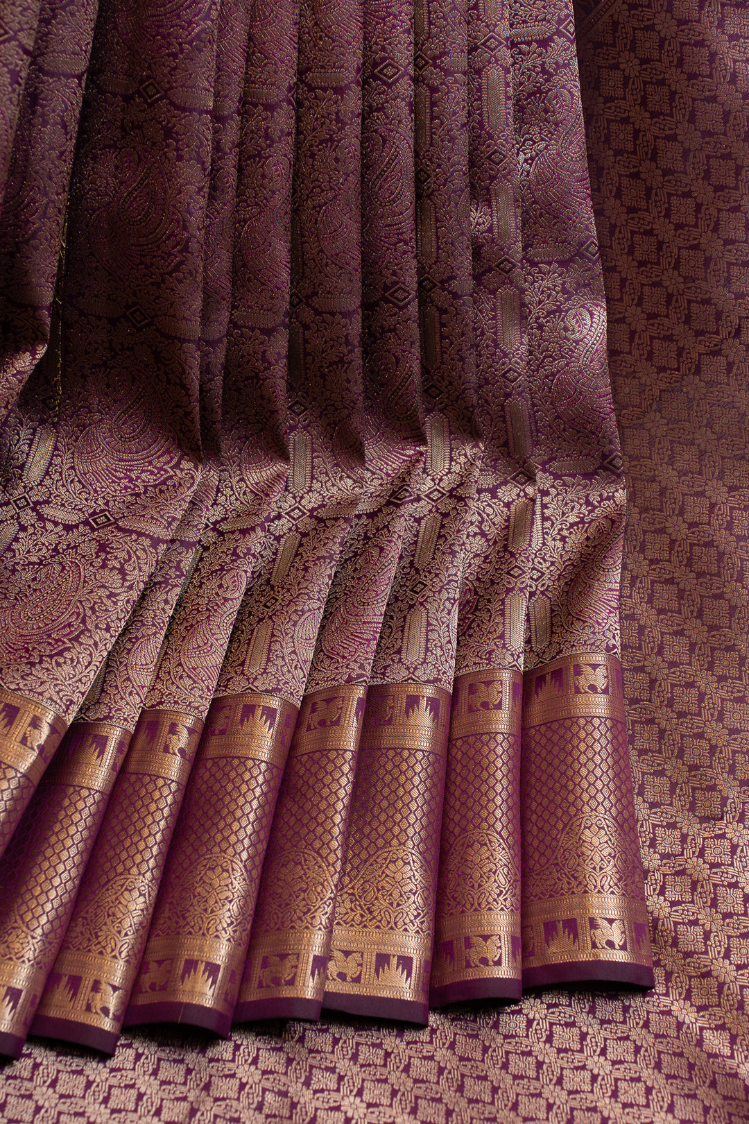 Close-up of a patterned fabric with gold accents on a textured background