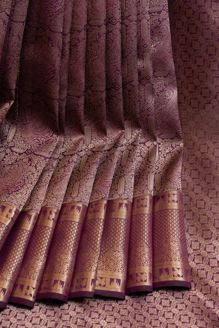 Close-up of a patterned fabric with gold accents on a textured background