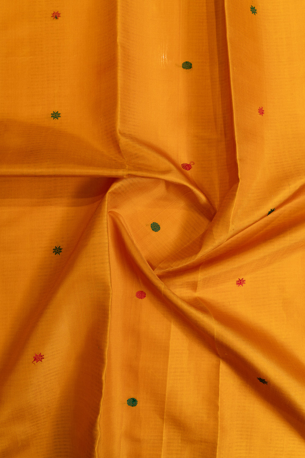 Close-up of orange fabric with small embroidered dots