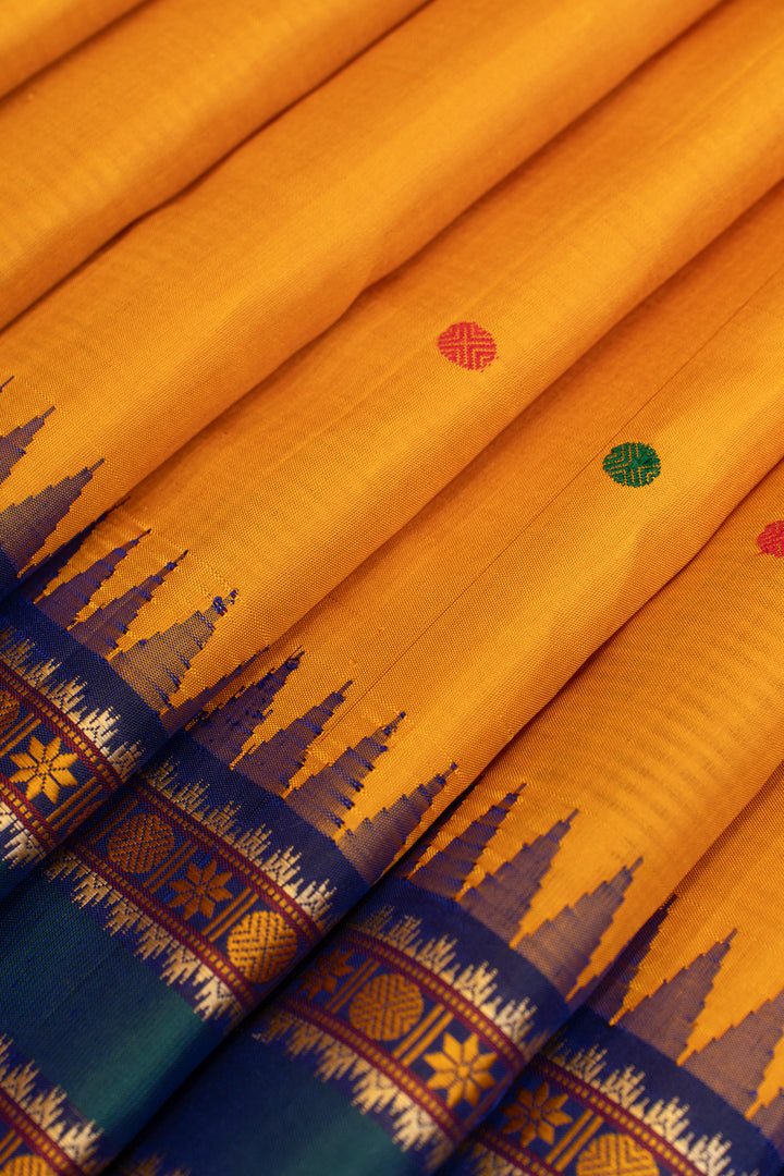 Close-up of a traditional fabric with intricate patterns on a yellow and blue background