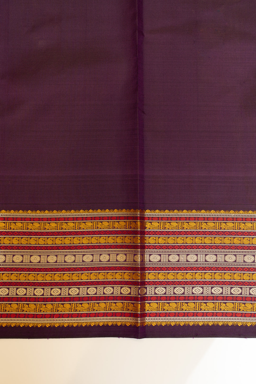 Purple fabric with a decorative yellow and red border