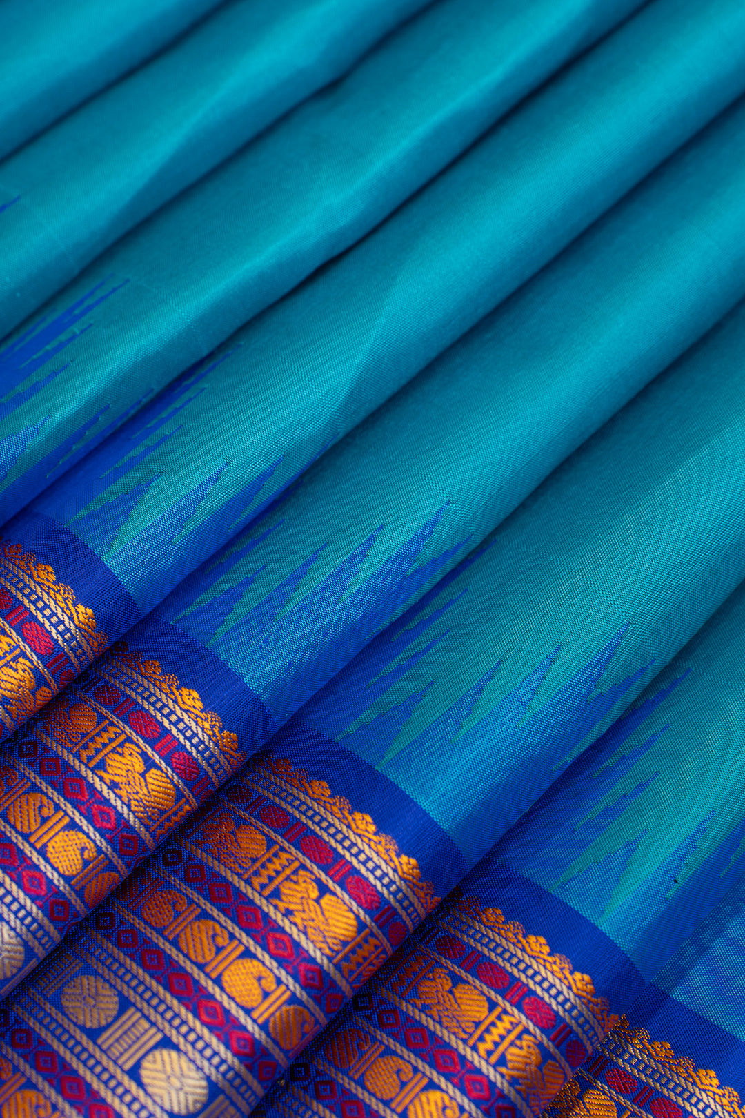 Close-up of a blue fabric with intricate patterns and borders