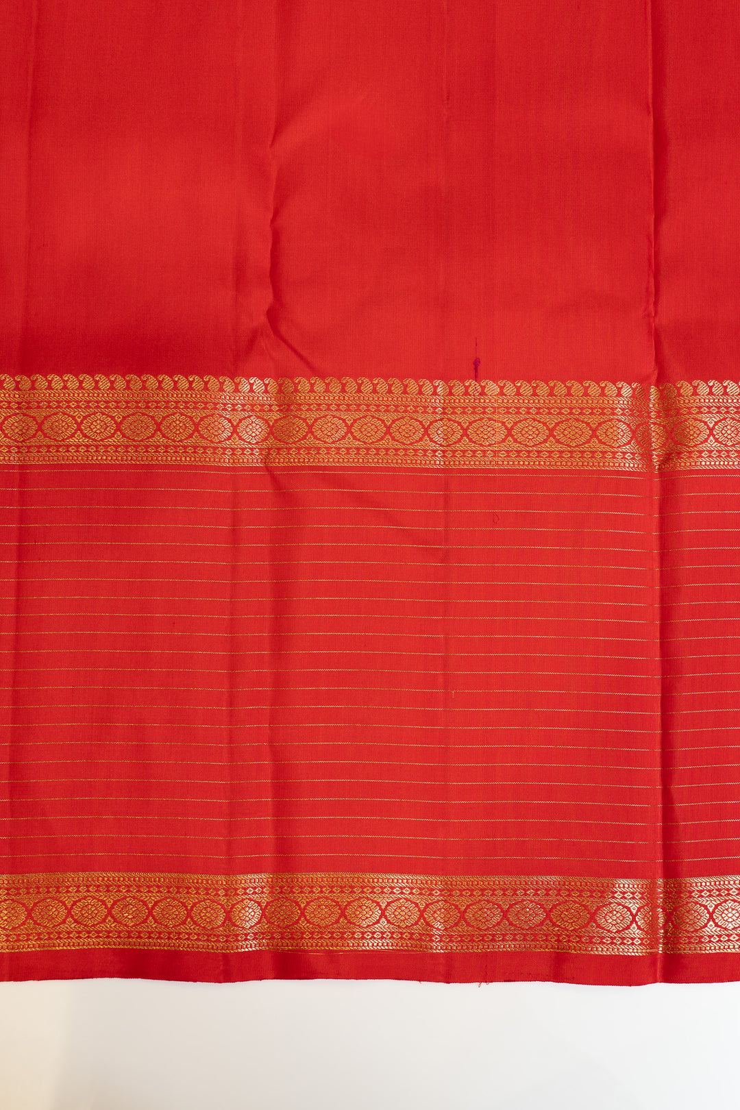 Red fabric with gold border on a white background