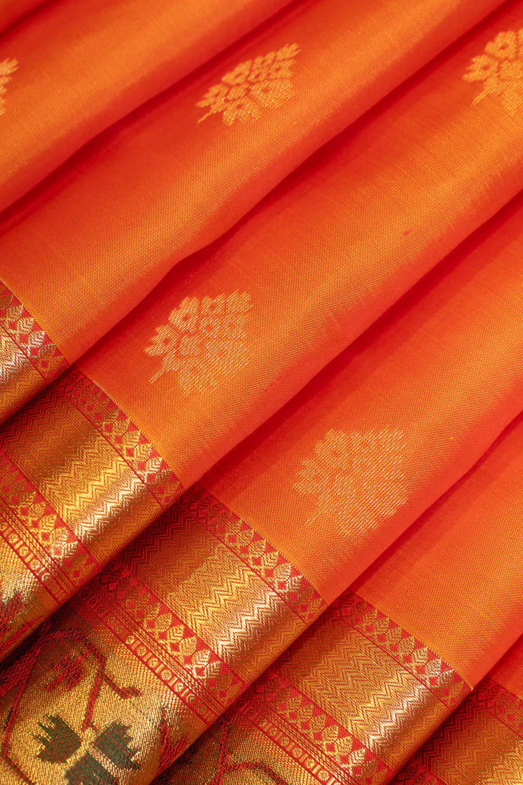 Close-up of an orange fabric with gold patterns