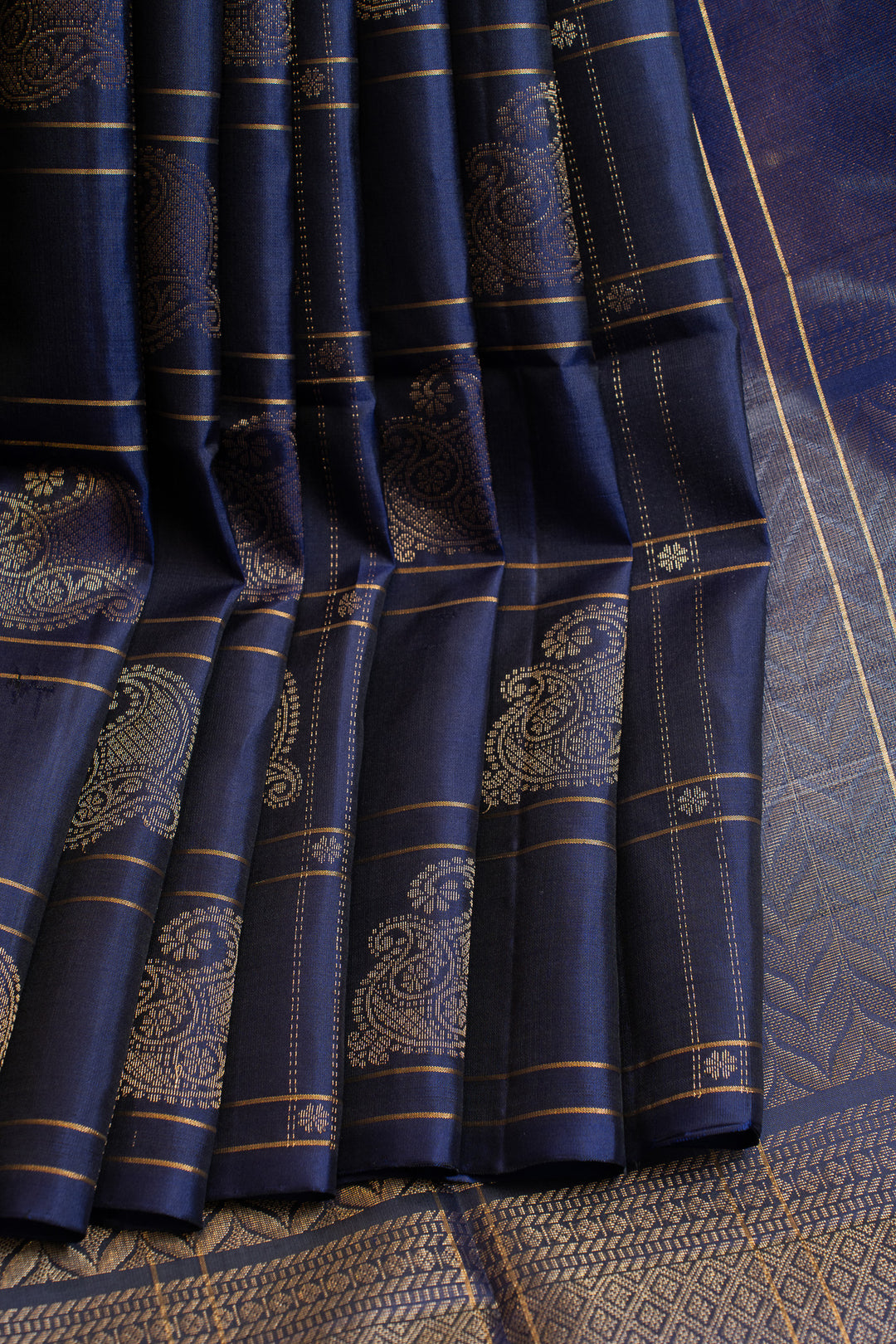 Close-up of blue fabric with intricate patterns and gold accents