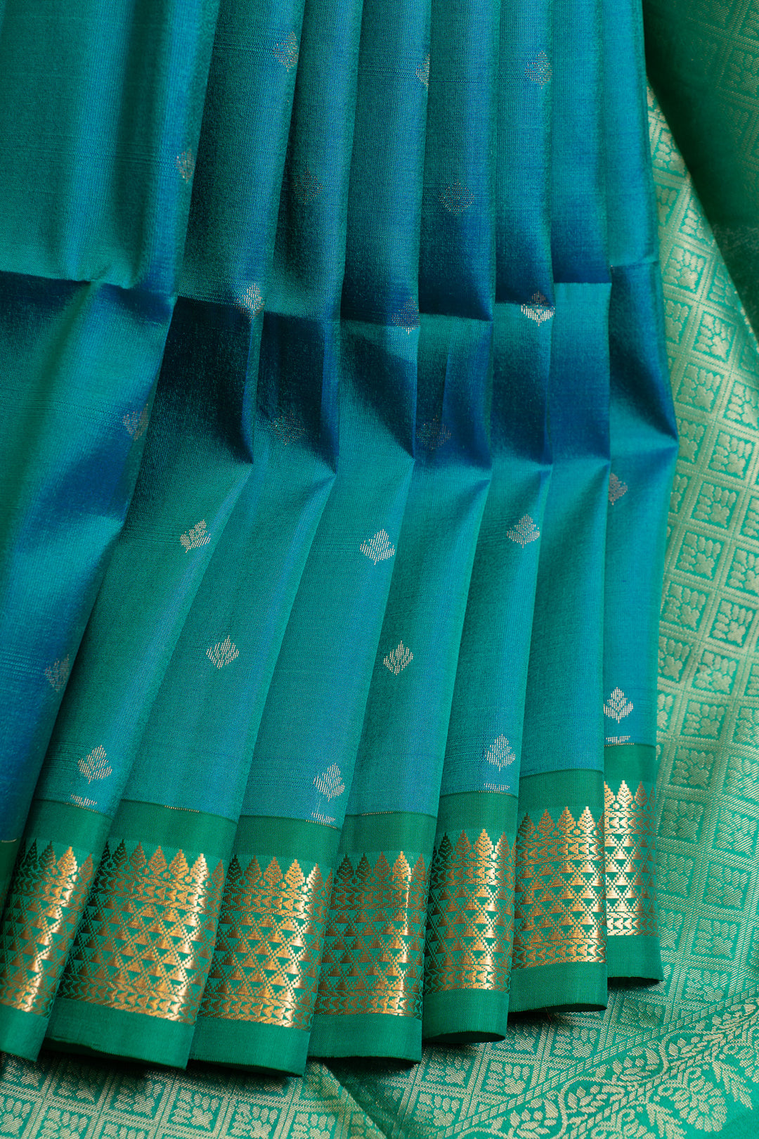 Teal saree with gold border and patterns