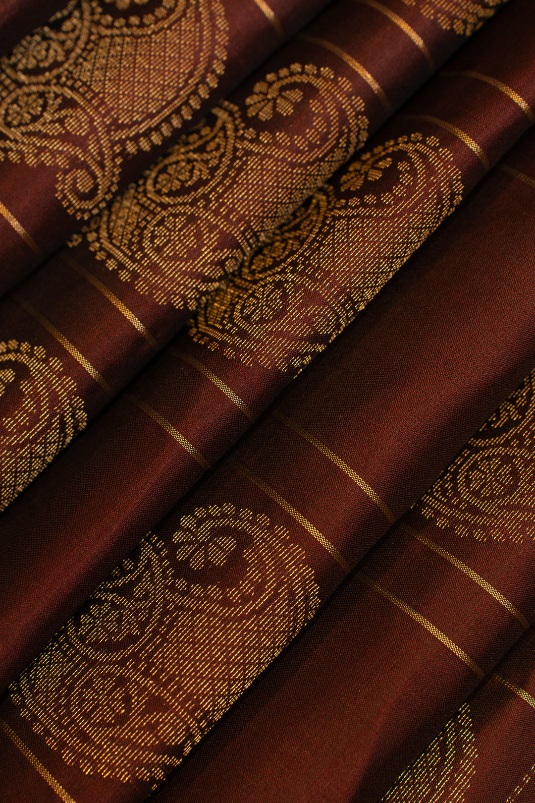 Close-up of brown fabric with gold paisley patterns