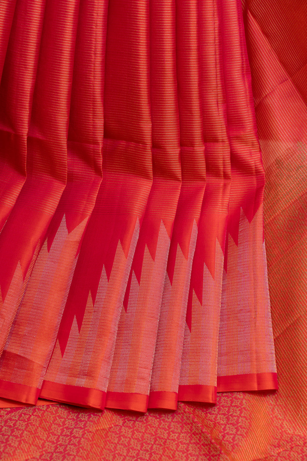 Close-up of a red and orange saree with a patterned border