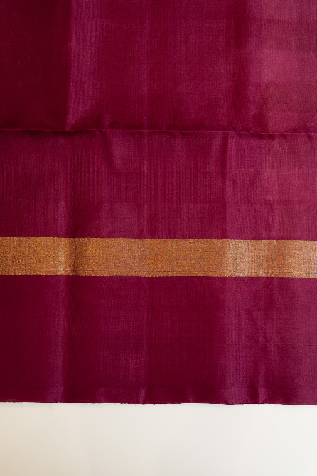 Maroon fabric with a gold border on a white background