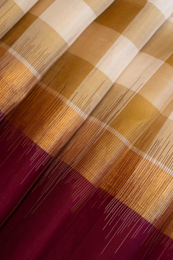 Close-up of plaid fabric with brown, beige, and red colors.
