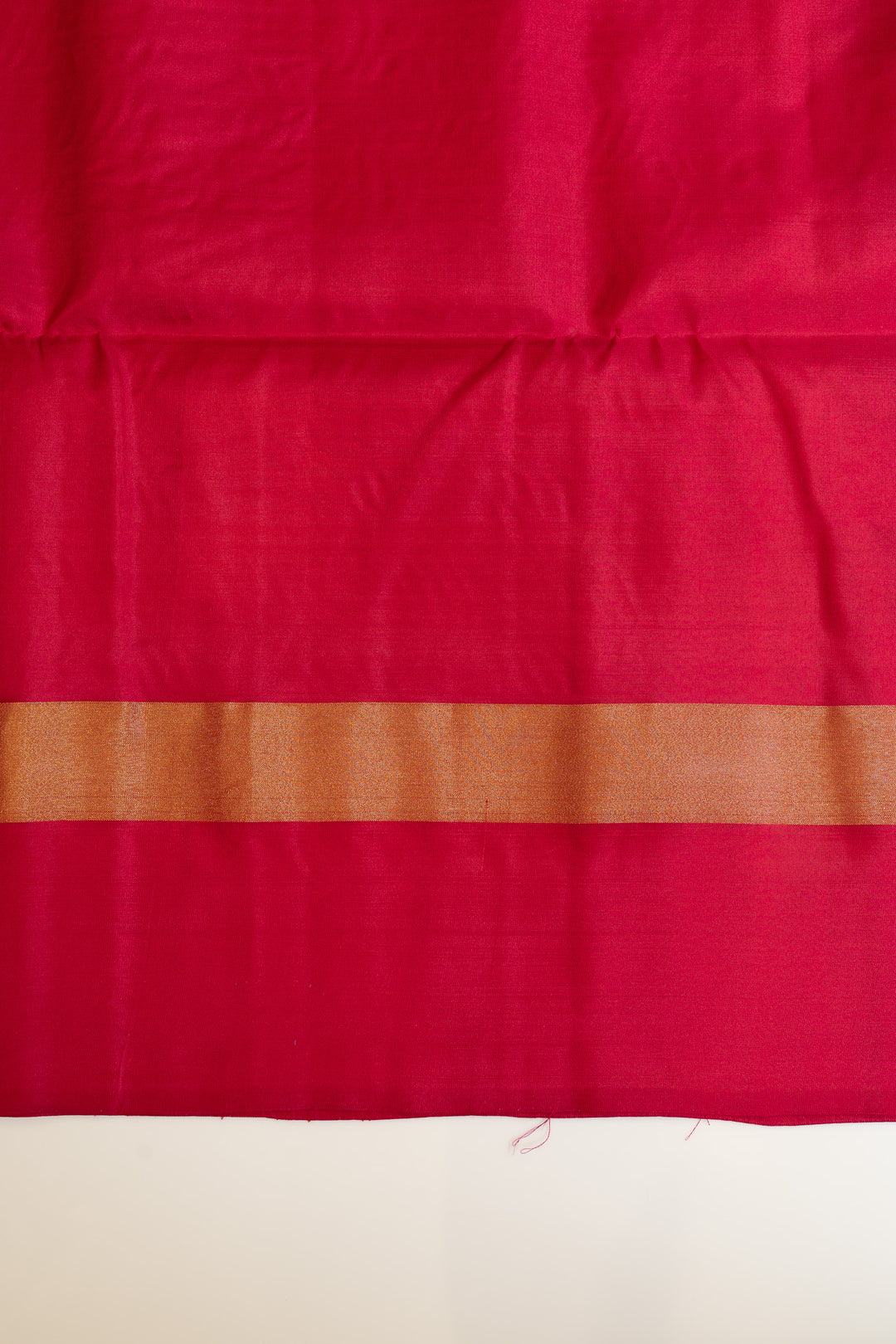 Red fabric with a brown band on a beige background
