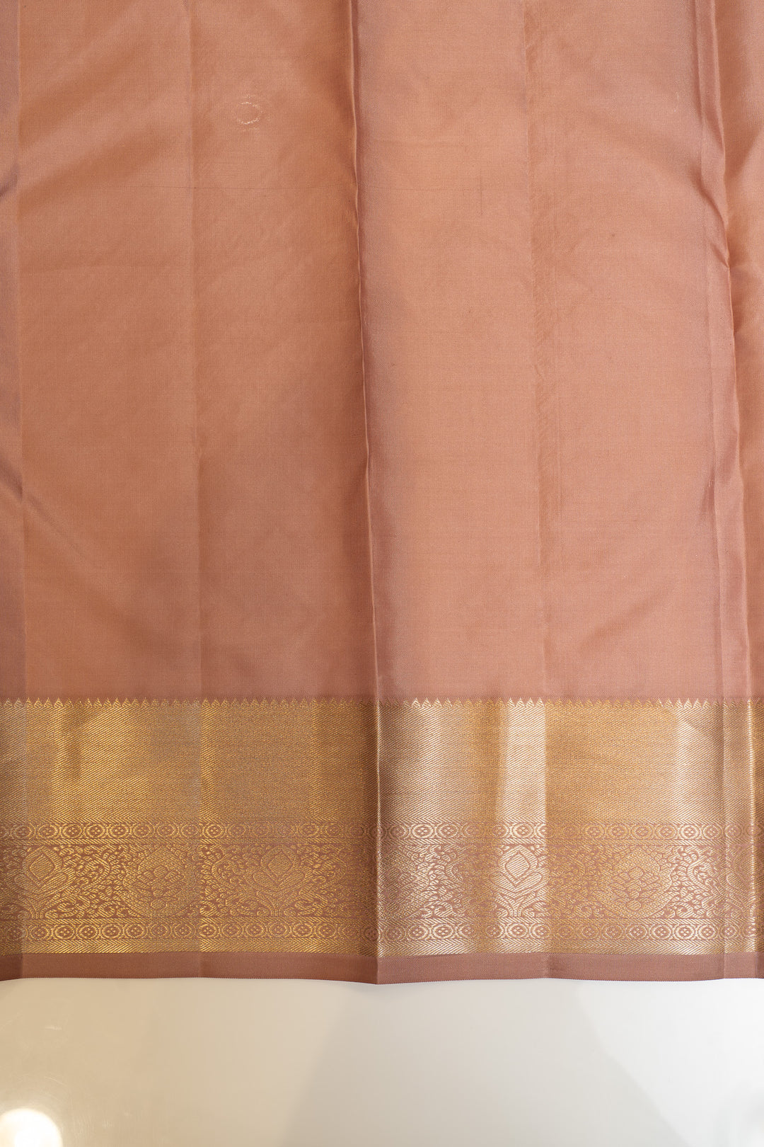 Pink saree with a gold border on a white background