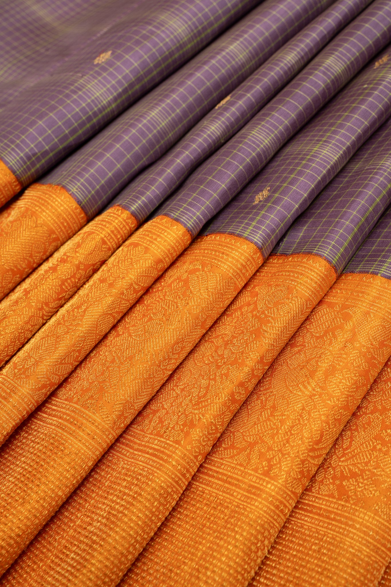 Detailed view of the pleats in the Iris Purple and Orange Kanchipuram silk saree, showcasing the rich texture and turning border design with gold zari