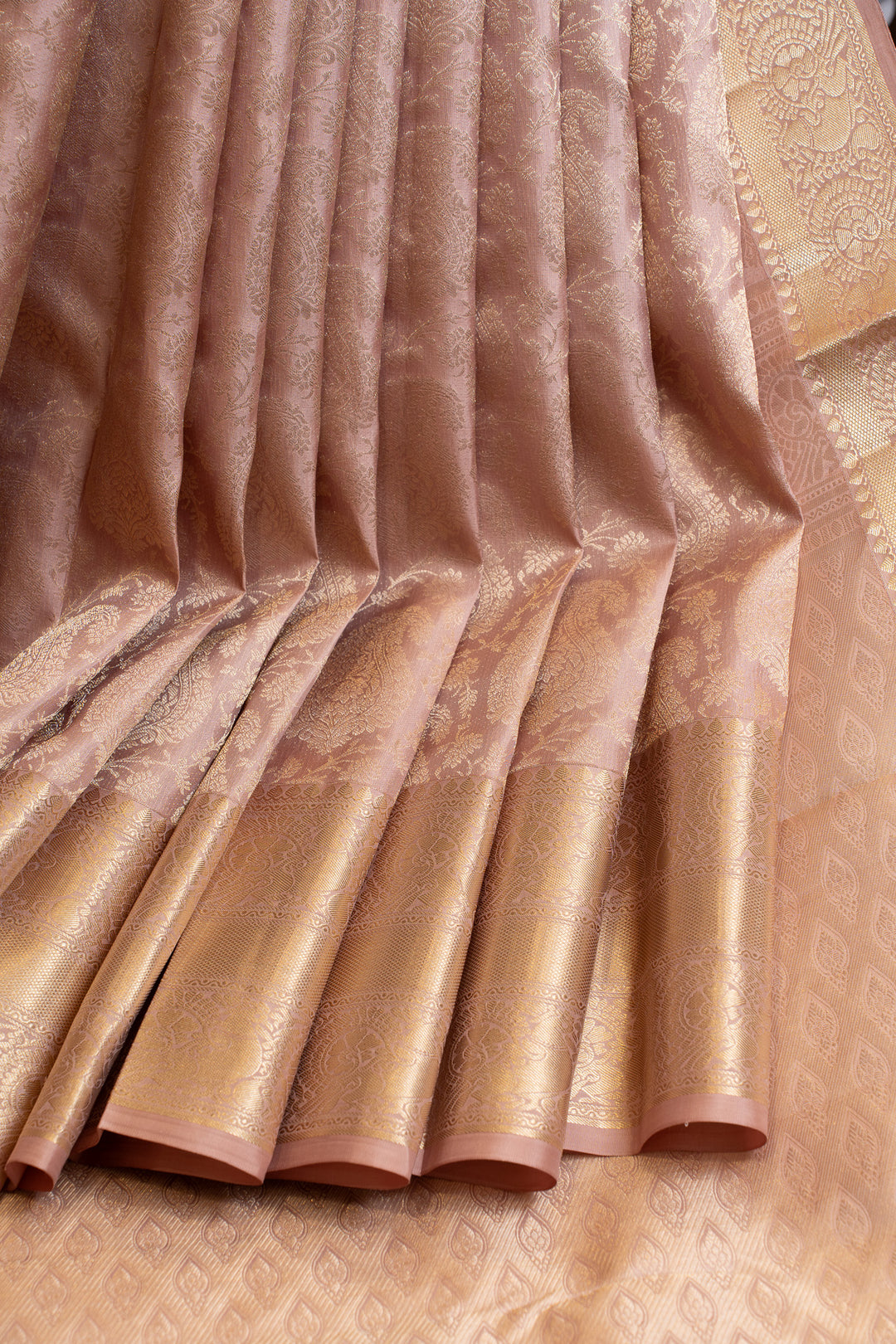 Close-up of a pink saree with gold border and pattern