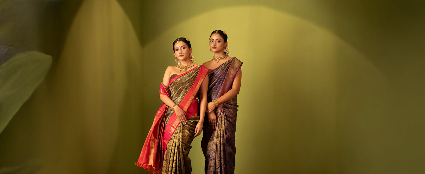 Two women elegantly dressed in Clio Silks' Eternal Saree Collection, wearing traditional Kanchipuram silk sarees with intricate handwoven designs and vibrant detailing